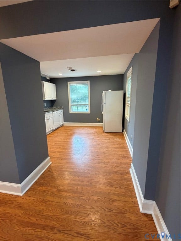 6323 Mallory Drive, Richmond, VA 23226 Kitchen area featuring wood-finish flooring, white cabinetry, dark countertops, and a window with blinds