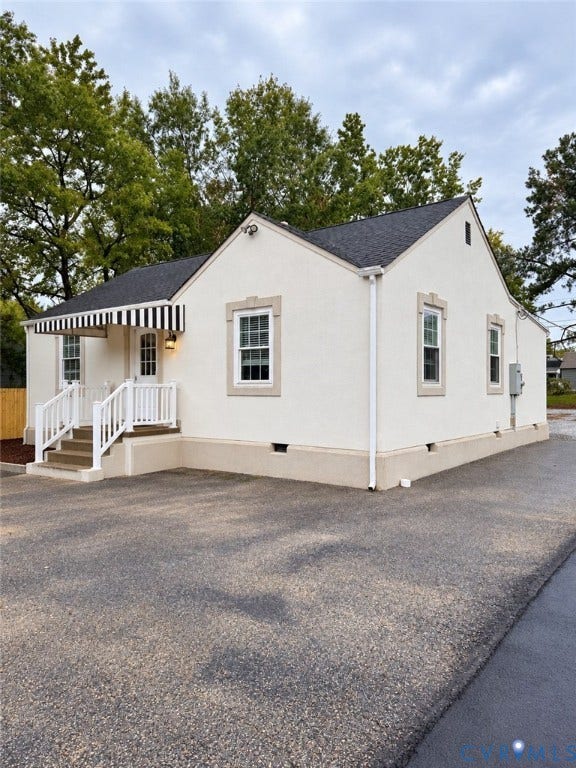 6323 Mallory Drive, Richmond, VA 23226 Stucco exterior featuring a black and white striped awning, white railings, and contrasting window trim