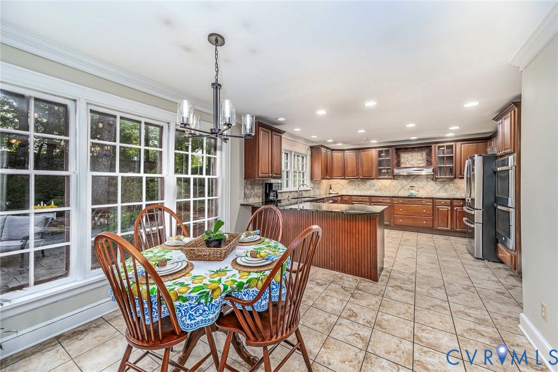 Kitchen with extensive wood cabinetry, tile flooring, and integrated double ovens