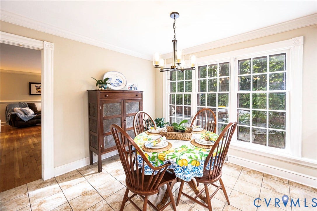 Tile flooring, extensive window system with mullions, crown molding, and a chandelier with glass shades