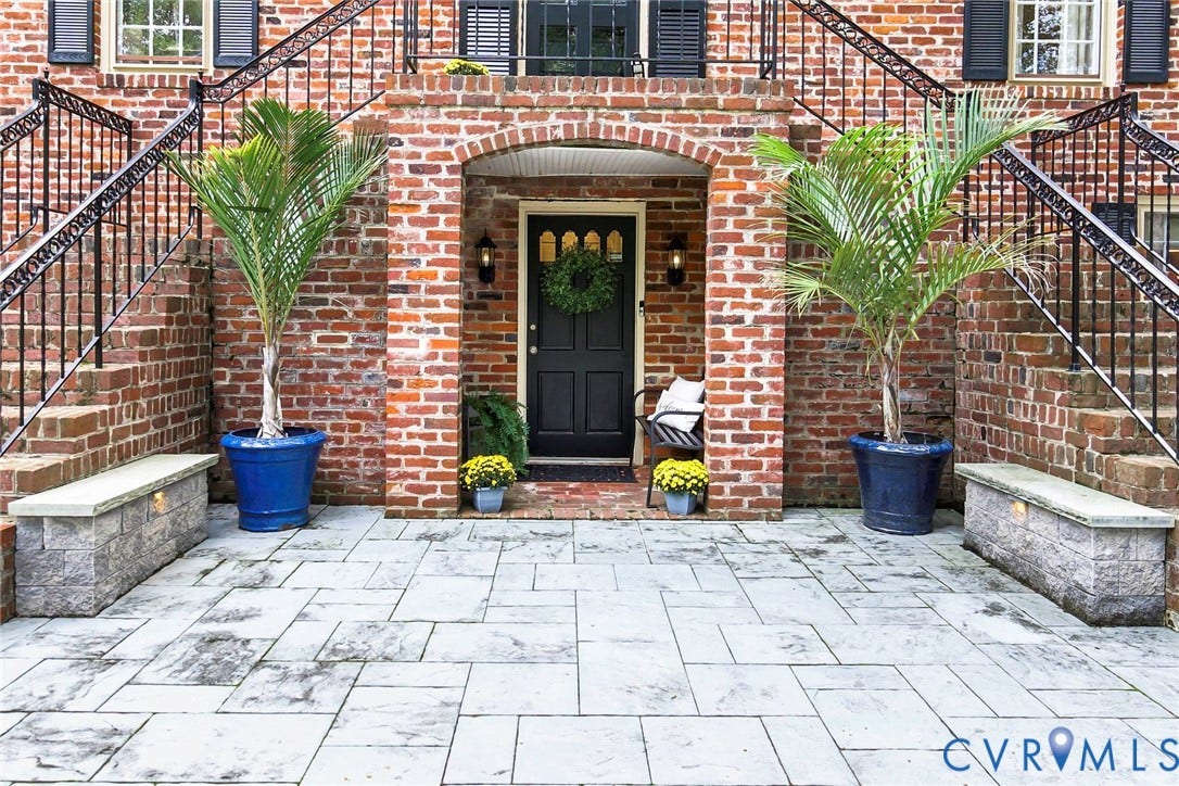 Brick exterior with symmetrical staircases featuring wrought iron railings