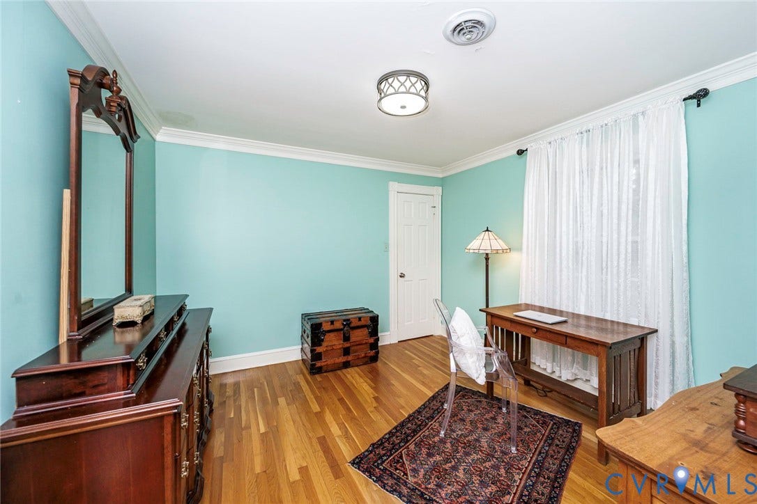 Hardwood flooring, crown molding, white trim, recessed lighting, and a window with sheer curtains