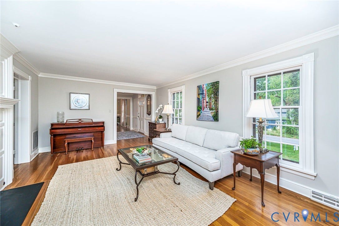 Hardwood flooring, painted walls, crown molding, white trim, and a fireplace with a white mantel