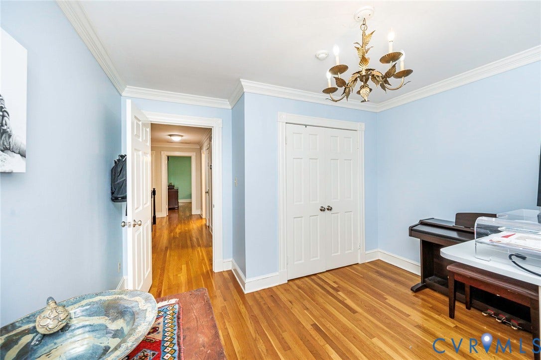 Hardwood flooring, crown molding, a brass-tone chandelier, and white trim