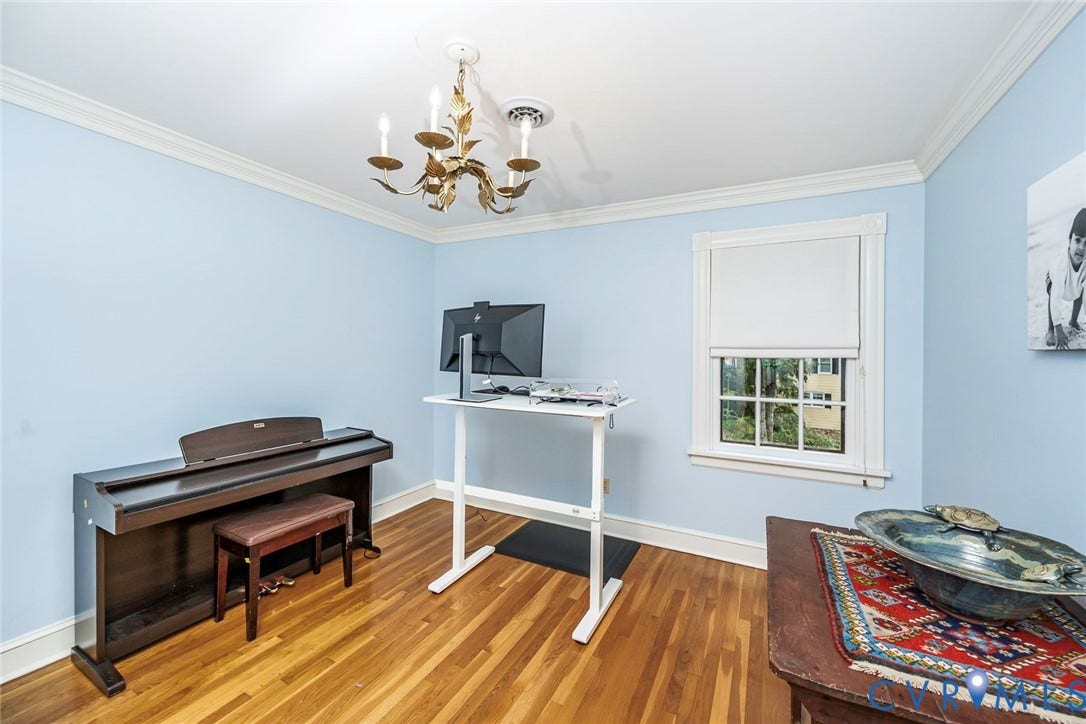 Hardwood flooring, crown molding, double-hung window, and a decorative ceiling light fixture