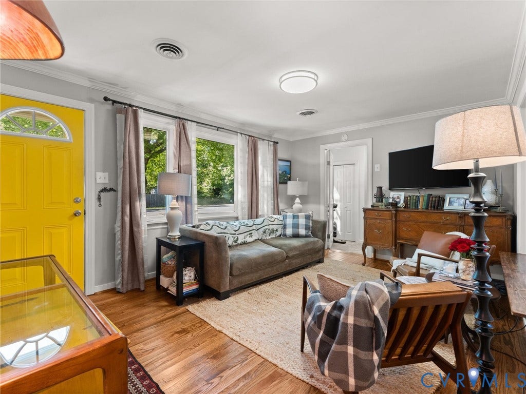 3933 Alma Avenue, Richmond, VA 23222 Hardwood flooring, natural light through multiple windows, crown molding, a vibrant yellow entry door with an arched transom, and a flush mount ceiling light fixture