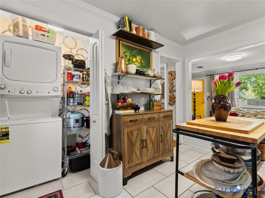 3933 Alma Avenue, Richmond, VA 23222 Stacked laundry appliances, built-in pantry with shelving, light-toned flooring, and a wood-finish cabinet with shelving
