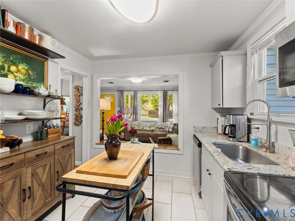 3933 Alma Avenue, Richmond, VA 23222 White cabinetry, quartz countertops, stainless steel appliances, and wood-finish flooring