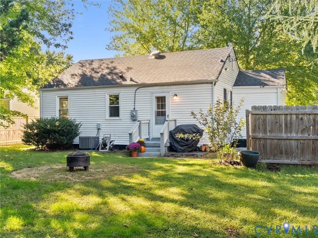 3933 Alma Avenue, Richmond, VA 23222 Expansive backyard featuring a manicured lawn, established shrubbery, and a wood privacy fence