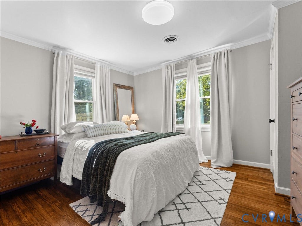 3933 Alma Avenue, Richmond, VA 23222 Hardwood flooring, crown molding, two large windows, white walls, and a ceiling-mounted light fixture