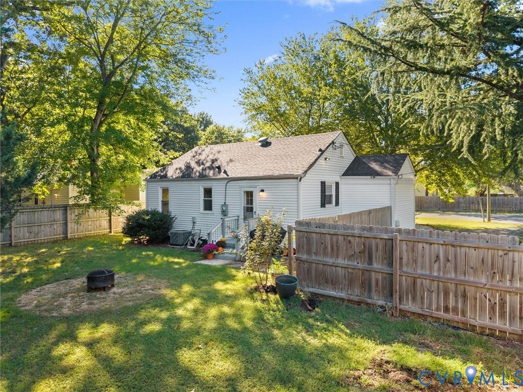 3933 Alma Avenue, Richmond, VA 23222 Private backyard with wood fencing, mature trees, and a ground-level deck