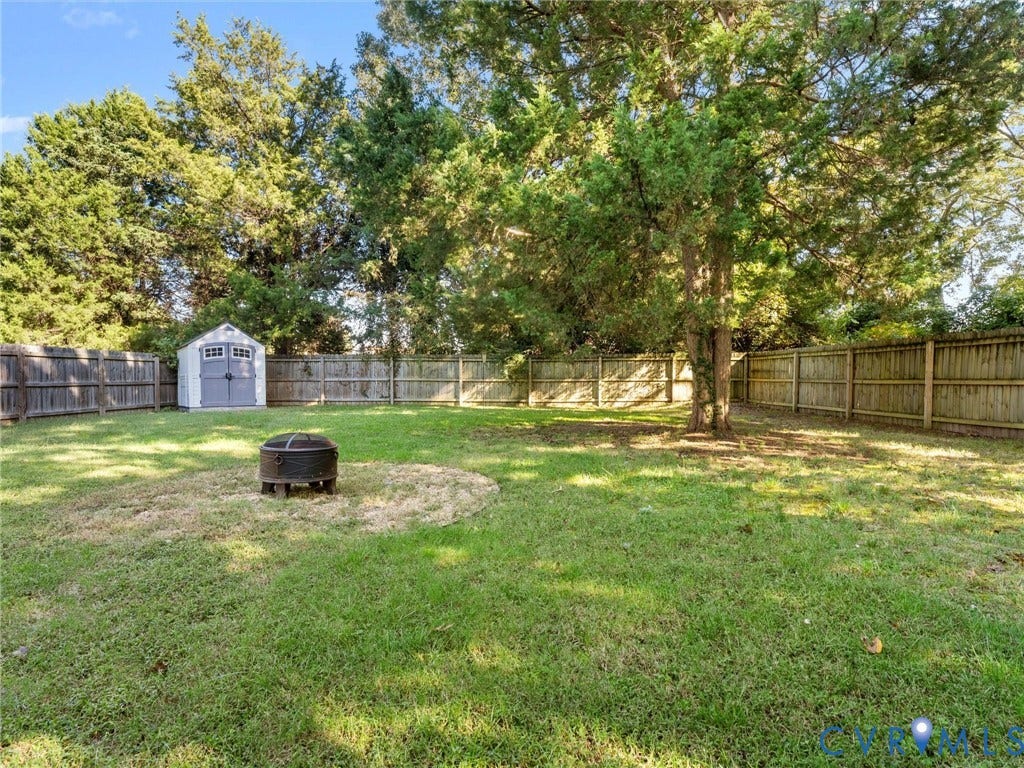 3933 Alma Avenue, Richmond, VA 23222 Fenced backyard featuring a storage shed, established trees, and a fire pit