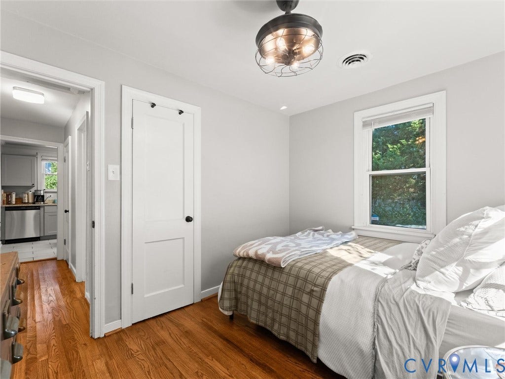 3933 Alma Avenue, Richmond, VA 23222 Hardwood flooring, painted walls, ceiling fan with metal caging, white trim window, and white interior doors