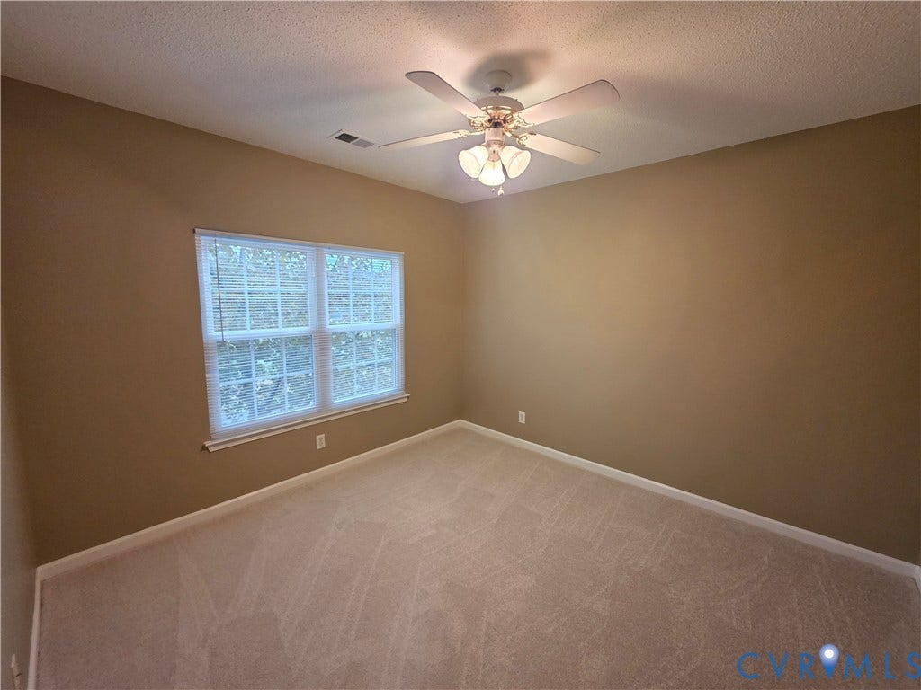 Neutral tone wall color, window with blinds, carpeted flooring, and ceiling fan with integrated lighting