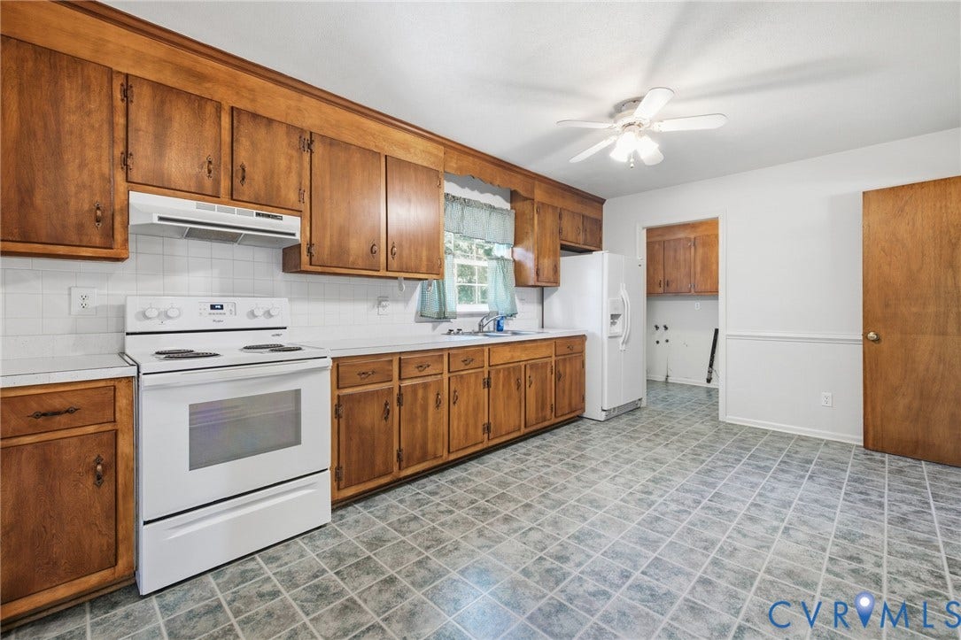 10215 River Road, South Chesterfield, VA 23803 Kitchen featuring wood-finish cabinetry, white appliances, white countertops, tile backsplash, and patterned flooring
