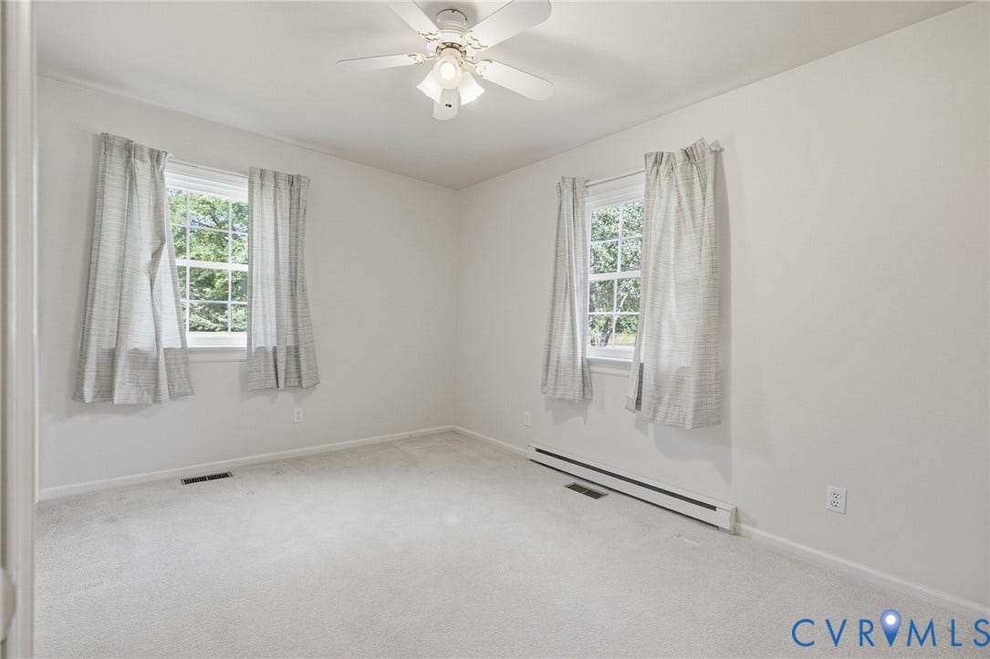 10215 River Road, South Chesterfield, VA 23803 Neutral-toned carpeting with white walls, dual windows, and a ceiling fan