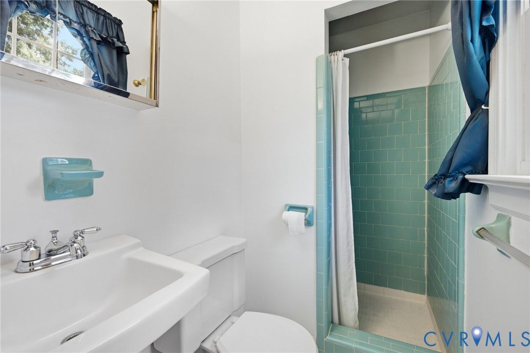 10215 River Road, South Chesterfield, VA 23803 Bathroom featuring a shower with teal subway tile, a white ceramic sink, and a toilet