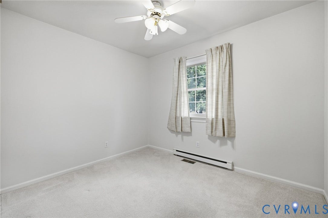 10215 River Road, South Chesterfield, VA 23803 Carpeted room with a ceiling fan, a window with curtains, and baseboard heating