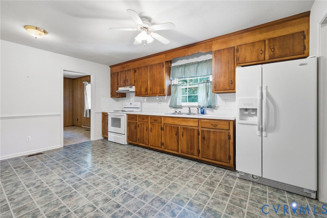 10215 River Road, South Chesterfield, VA 23803 Kitchen featuring wood cabinetry, white appliances, patterned floor tile, and a ceiling fan with integrated lighting