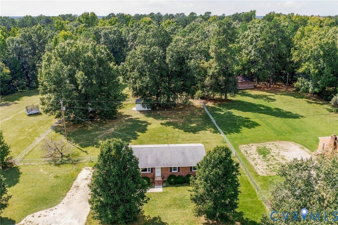 10215 River Road, South Chesterfield, VA 23803 Expansive property featuring a single-story brick residence, mature trees, and a gravel driveway