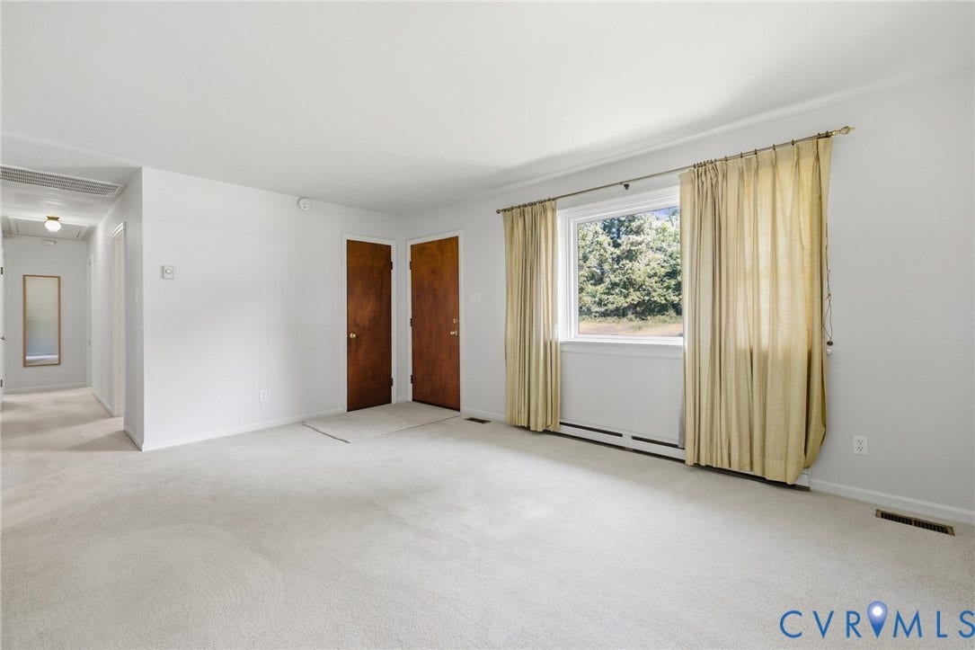 10215 River Road, South Chesterfield, VA 23803 Light-colored wall-to-wall carpeting throughout, light-toned walls, and a window with a wooded backdrop