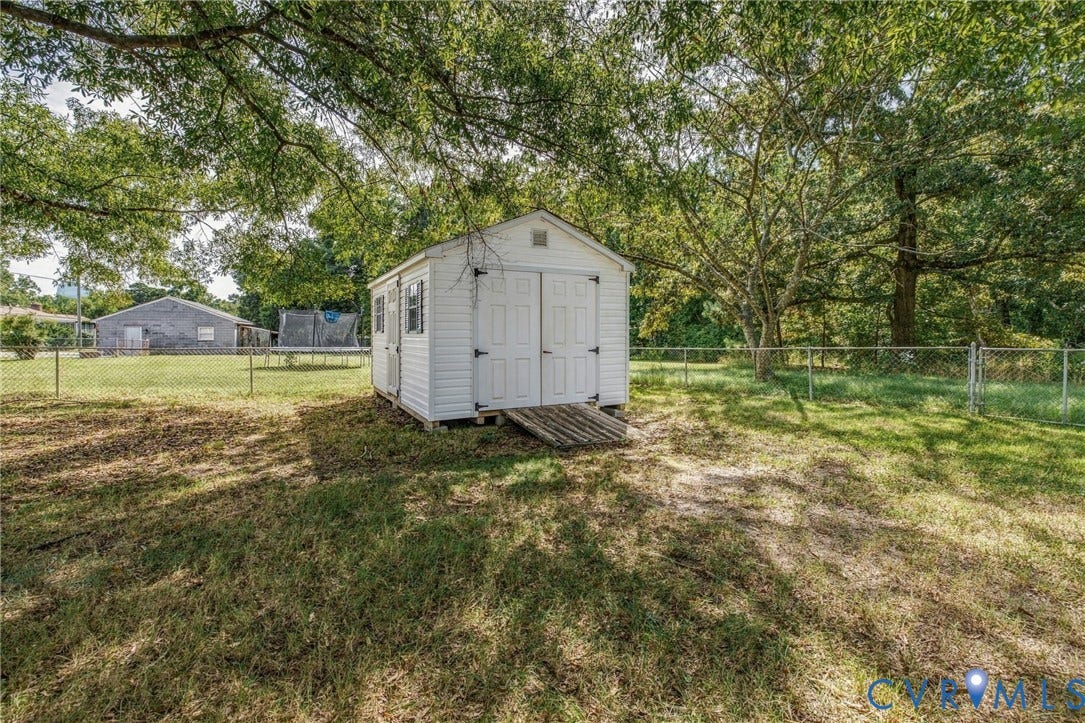 10215 River Road, South Chesterfield, VA 23803 White storage shed with double doors, wood ramp, and two side windows