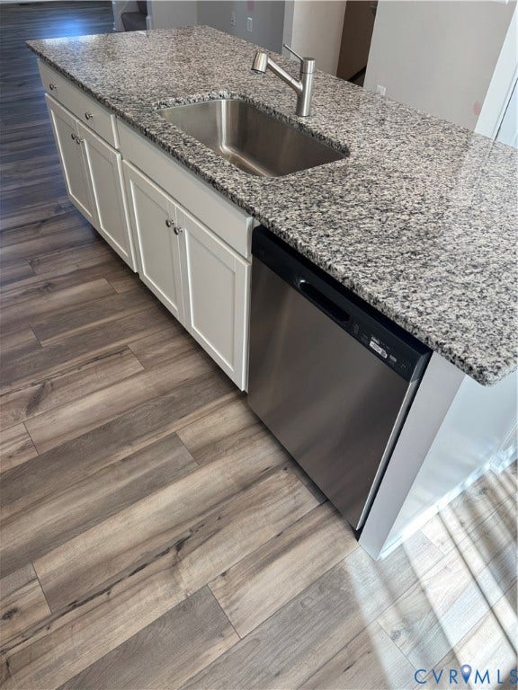 16025 Abelson Way, Chesterfield, VA 23832 Kitchen island featuring a stainless steel sink with a modern faucet, granite countertop, white cabinetry with silver hardware, and an integrated stainless steel dishwasher.