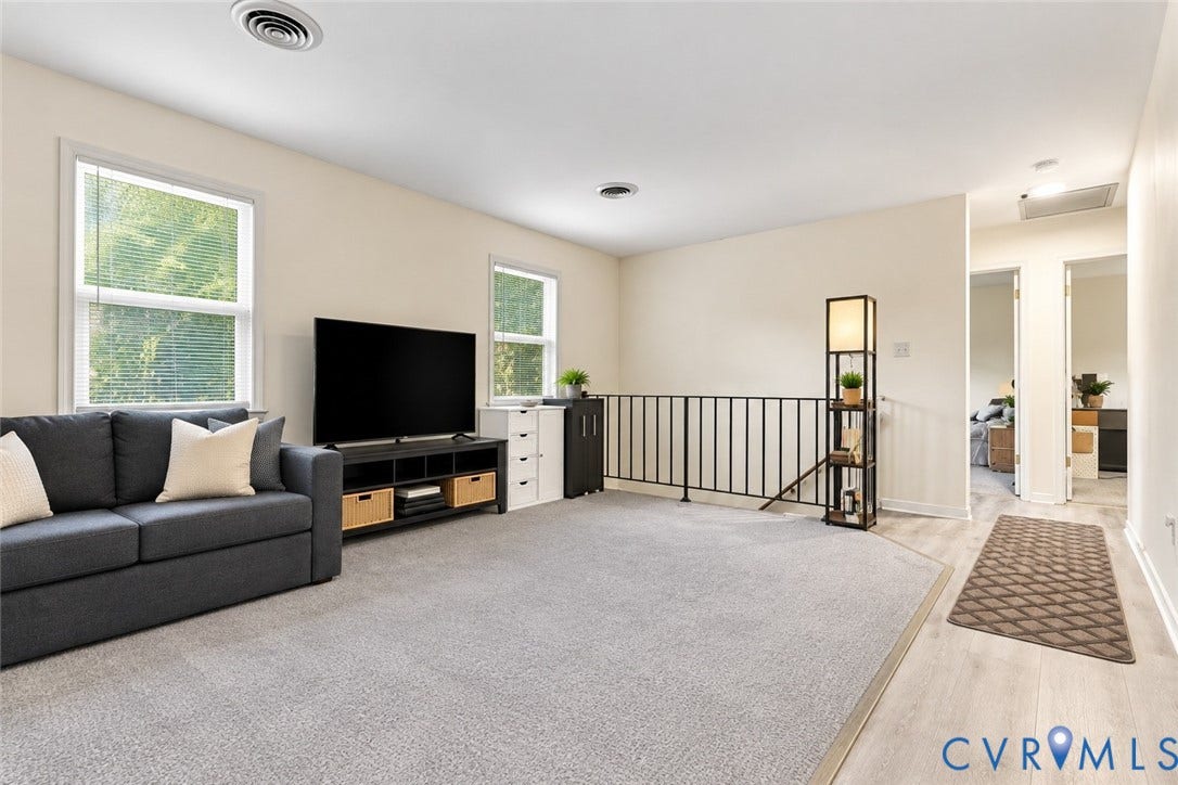 12308 Poplar Forest Drive, Tuckahoe Village, Henrico, VA 23238 Carpeted living area with two windows, a black metal railing, and light-toned walls