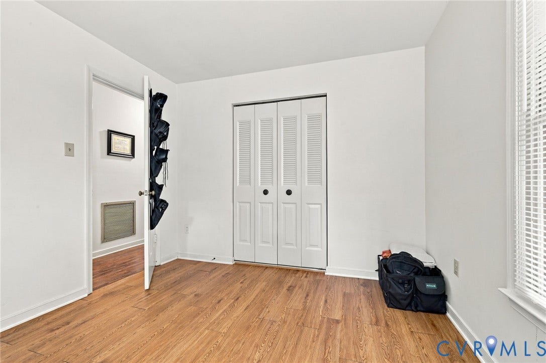 12308 Poplar Forest Drive, Tuckahoe Village, Henrico, VA 23238 Wood-finish flooring, white walls, louvered bi-fold closet doors, and a window with blinds