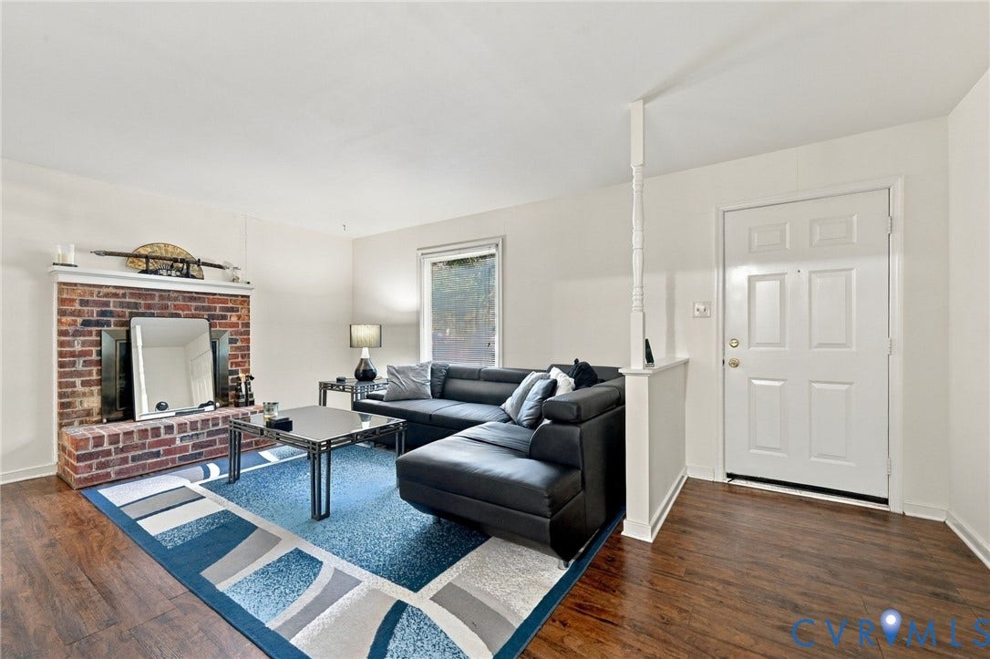 12308 Poplar Forest Drive, Tuckahoe Village, Henrico, VA 23238 Brick fireplace with a white mantel, wood-finish flooring, white paneled entry door, and a partition wall with decorative baluster