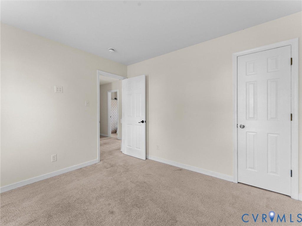 Neutral paint tones, carpeted flooring, white trim, and white paneled doors