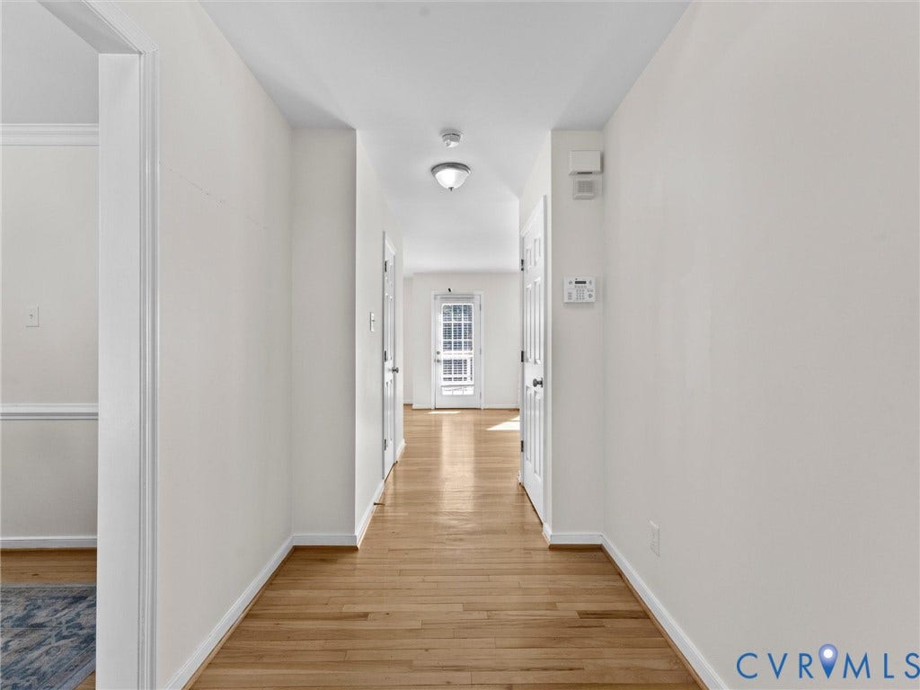 Hardwood flooring throughout, white painted walls, white trim, and a semi-flush mount ceiling light