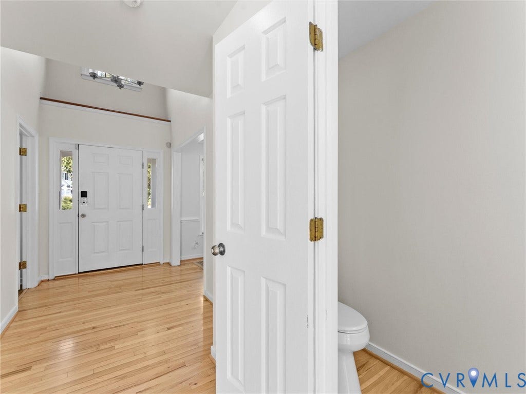 Hardwood flooring, paneled interior doors, and a double front door with sidelight windows