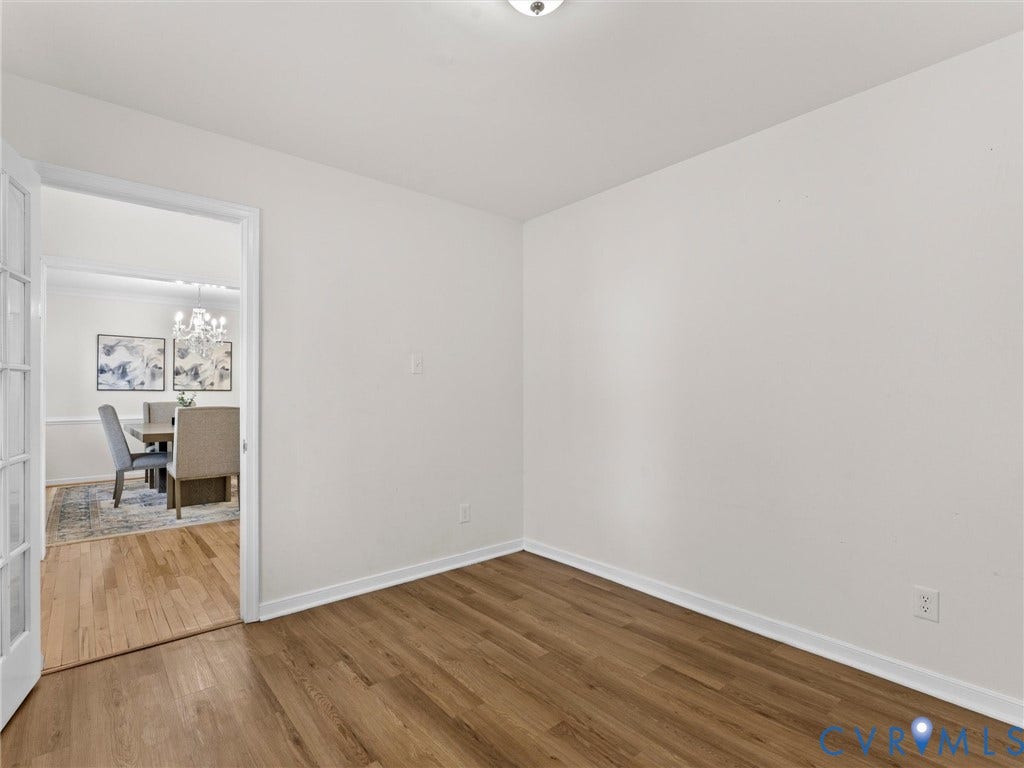 Wood-finish flooring with white baseboards and light-toned walls