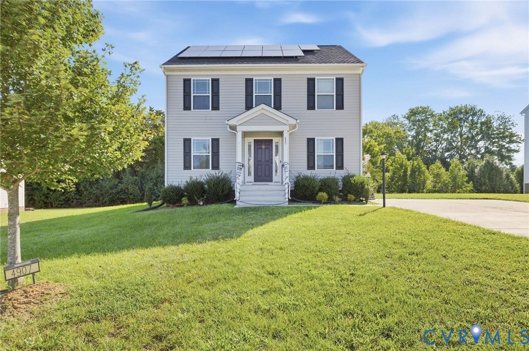 Two-story residence featuring light gray siding, black shutters, and a covered entry porch