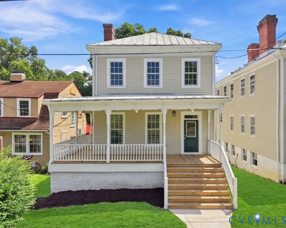 104 E Fillmore Street, Petersburg, VA 23803 Two-story exterior with light-colored siding, a covered front porch with decorative trim, a dark green entry door, and a metal roof
