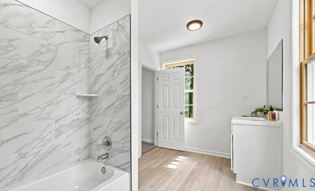 104 E Fillmore Street, Petersburg, VA 23803 Bathroom featuring a tub/shower combination with marble-look tile surround and chrome fixtures