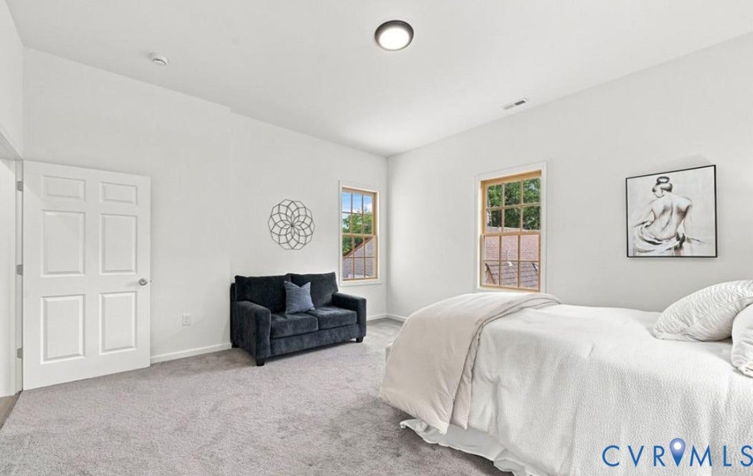 104 E Fillmore Street, Petersburg, VA 23803 Light gray carpeting, white painted walls, white paneled door, and two single-pane windows with wood trim