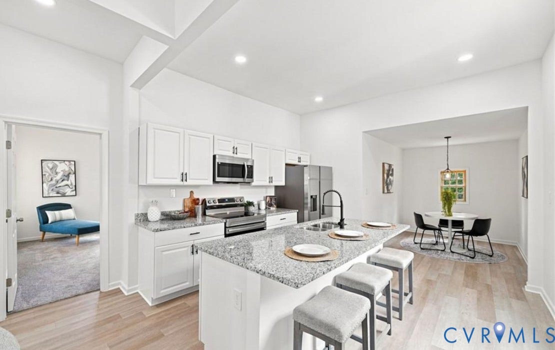 104 E Fillmore Street, Petersburg, VA 23803 Open-concept kitchen and dining area featuring white cabinetry, stainless steel appliances, granite countertops, and a center island with seating