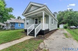 222 Elm Street, Petersburg, VA 23803 Gable roofline, light-colored siding exterior, covered front porch, white railings, and concrete walkway