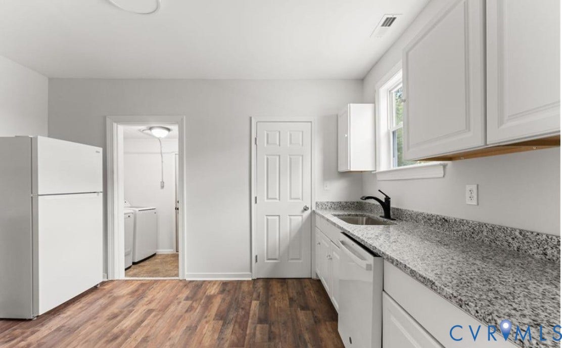 222 Elm Street, Petersburg, VA 23803 Kitchen featuring wood-finish flooring, white cabinetry, a stainless steel sink with a matte black faucet, and speckled countertops