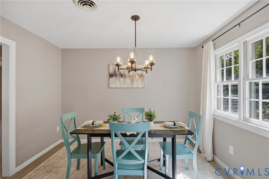 Recessed ceiling vent, wood-finish flooring, two large windows, white trim, and a contemporary chandelier