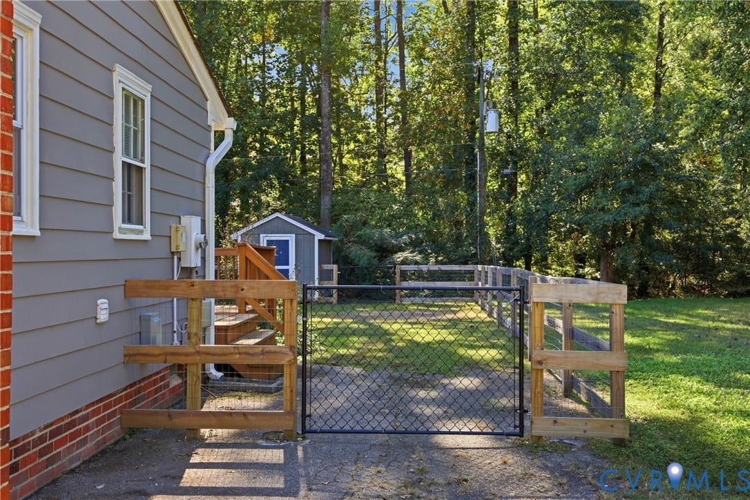 Gray siding with white trim, brick foundation, and an outdoor staircase with wood railings