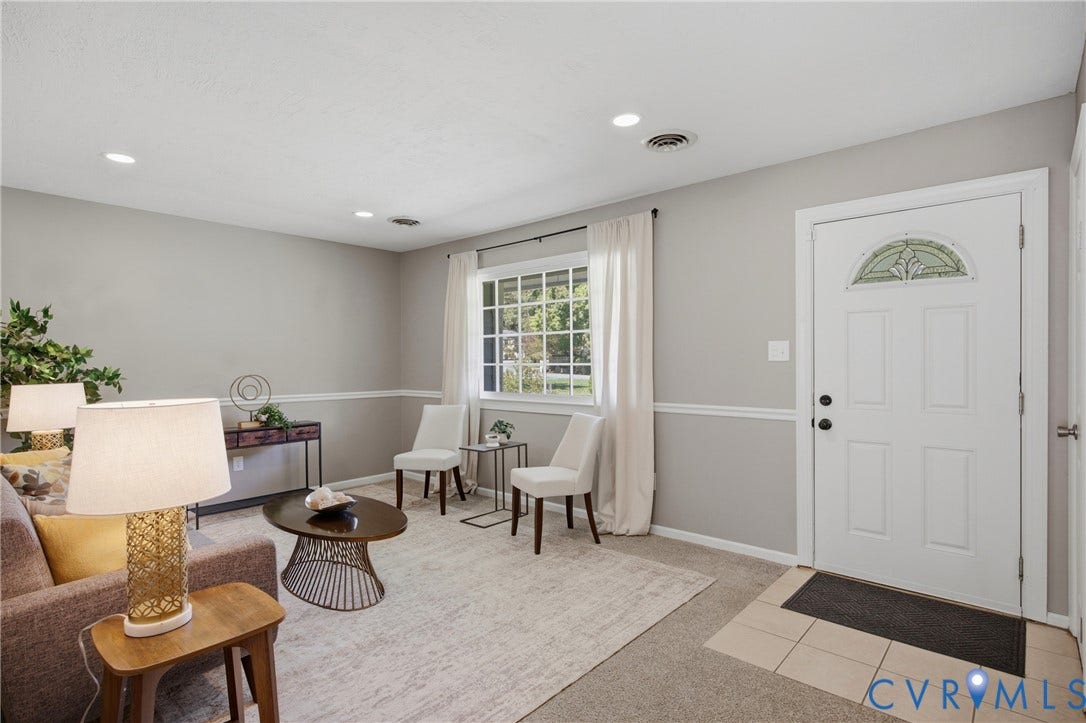 Recessed lighting, window with white curtains, white paneled door with decorative glass insert, chair rail molding, and tile flooring at entry