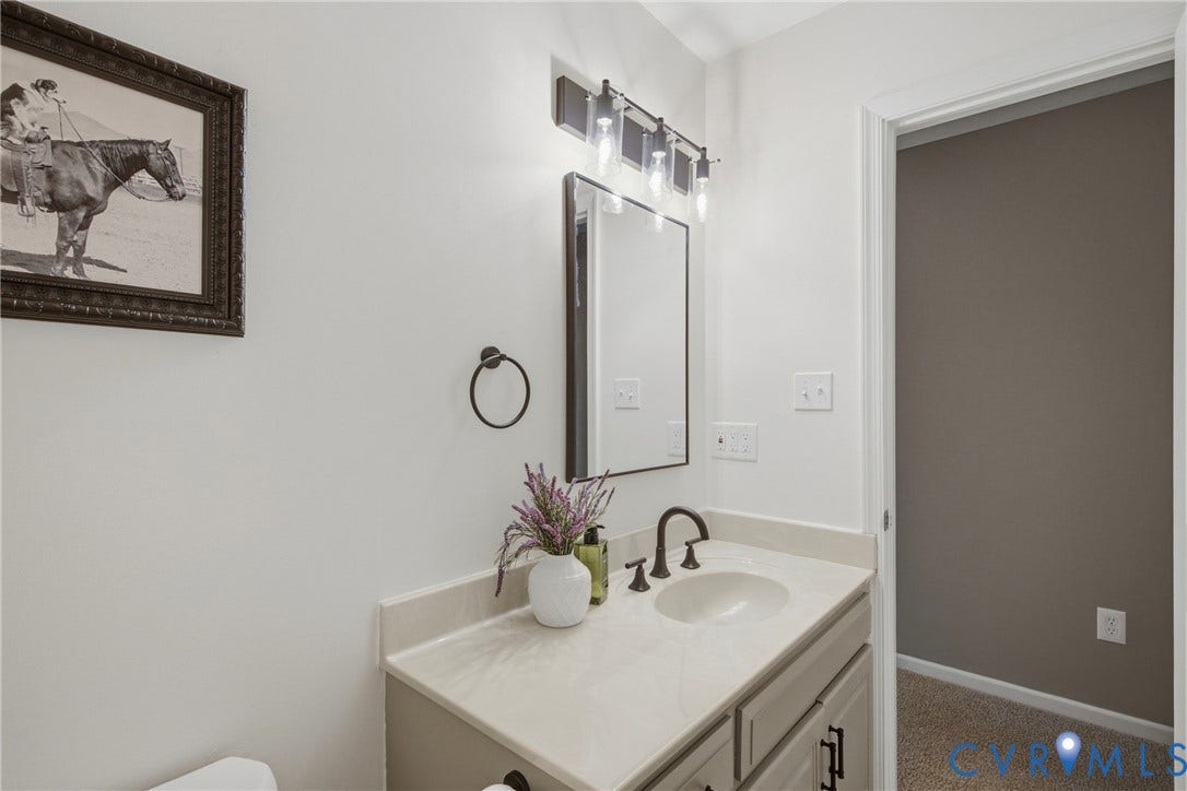 Vanity with an integrated sink, dark bronze fixtures, and a wall-mounted light fixture