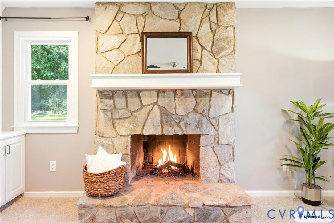 Stone-clad fireplace with a hearth and white mantel