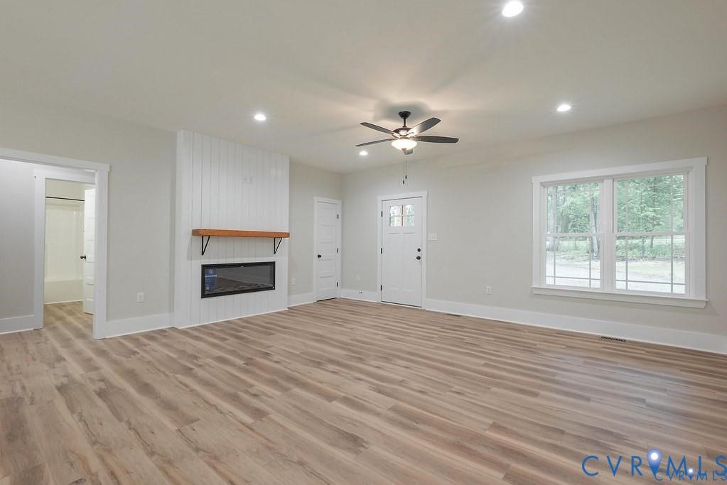 5301 Chimney Springs Drive, Goochland, VA 23063 Wood-finish flooring, recessed lighting, and an electric fireplace with a wood mantle