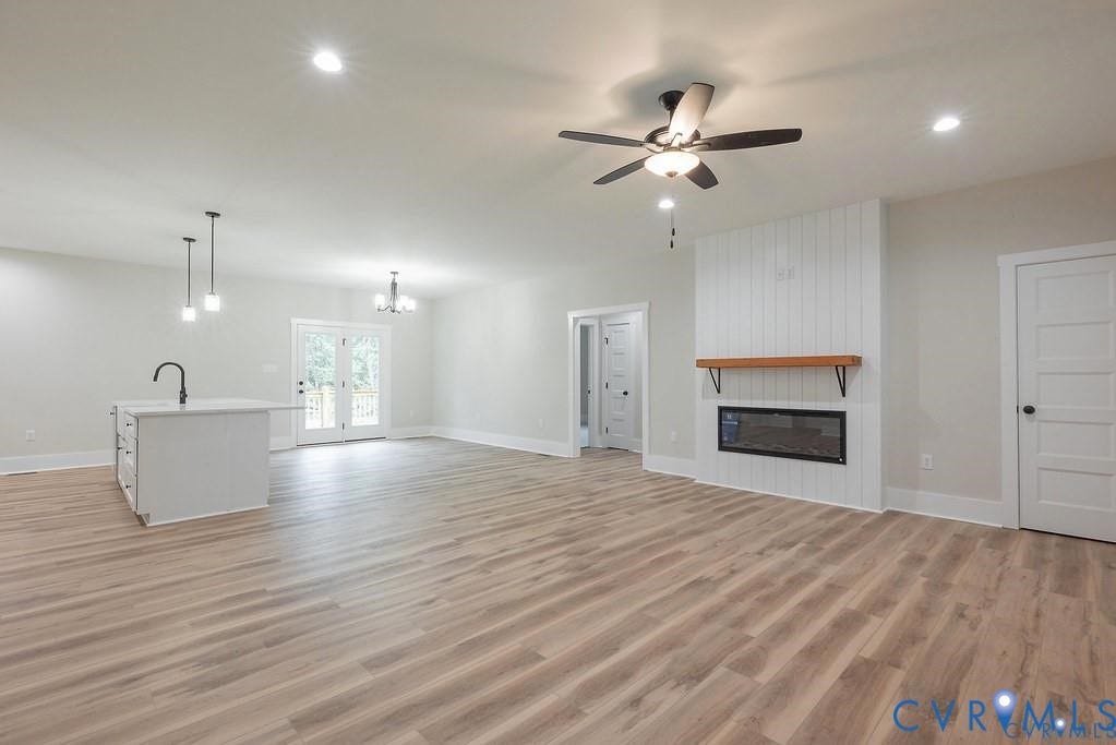 5301 Chimney Springs Drive, Goochland, VA 23063 Spacious open-concept interior with wood-finish flooring, recessed lighting, and a contemporary fireplace with a wood mantel