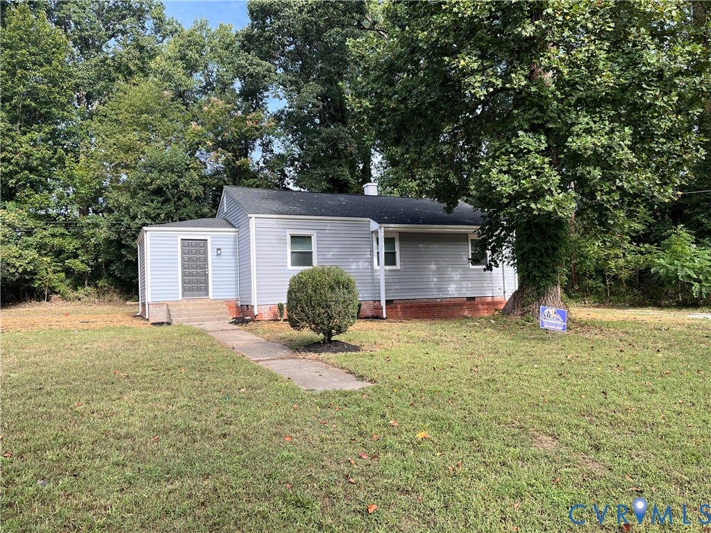 634 Fayette Avenue, Richmond, VA 23222 Light-colored siding exterior with a dark roof, featuring a concrete walkway, mature landscaping, and a front entry with a decorative screen door