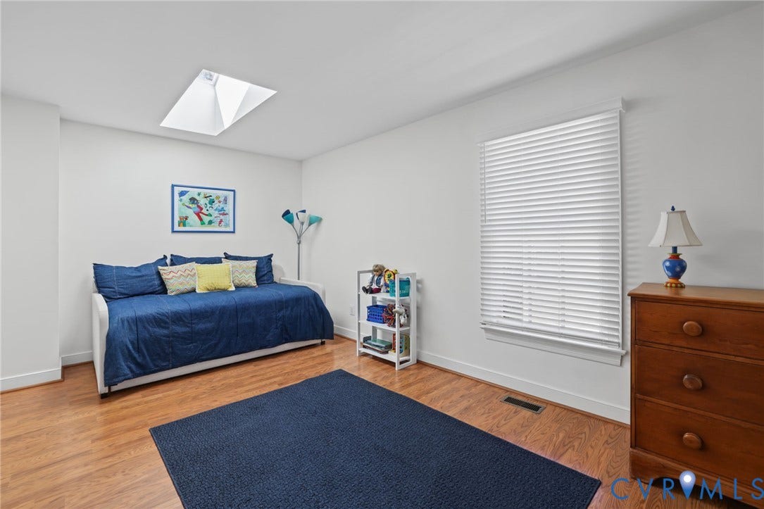Wood-look laminate flooring, white walls, and a skylight provide a bright atmosphere